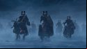 A group of charging Skullcrushers, heavy cavalry of Khorne wearing chunky red and brass armour, in Total War: Warhammer 3