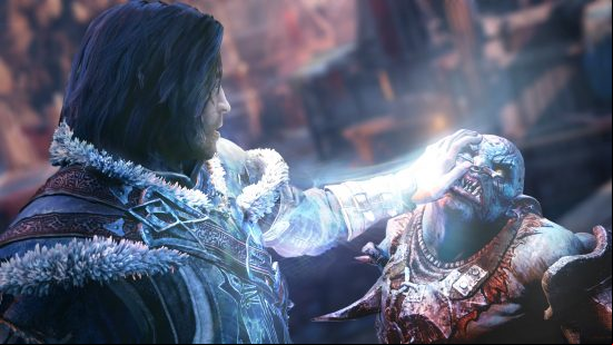 Best action-adventure games - a man places his hand on an orc's face in Middle-earth: Shadow of Mordor.