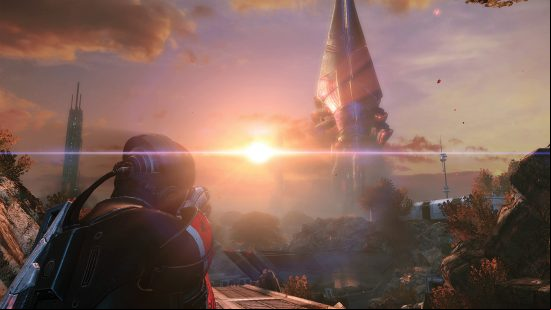 Best space games: A character in futuristic clothes looking at the sun setting on an alien planet in Mass Effect: Legendary Edition.