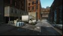 Escape from Tarkov screenshots: A large  truck in a loading area in an alleyway lined by the walls of a large red brick industrial building