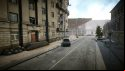Escape from Tarkov screenshots: An empty city street lined with abandoned residential buildings and leading to a modern-style museum, with a pickup truck that has crashed into a streetlight on the left side