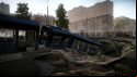 Escape from Tarkov screenshots: A tram has fallen through the street into a sinkhole leading to an underground sewer or culvert; large apartment buildings can be seen in the background