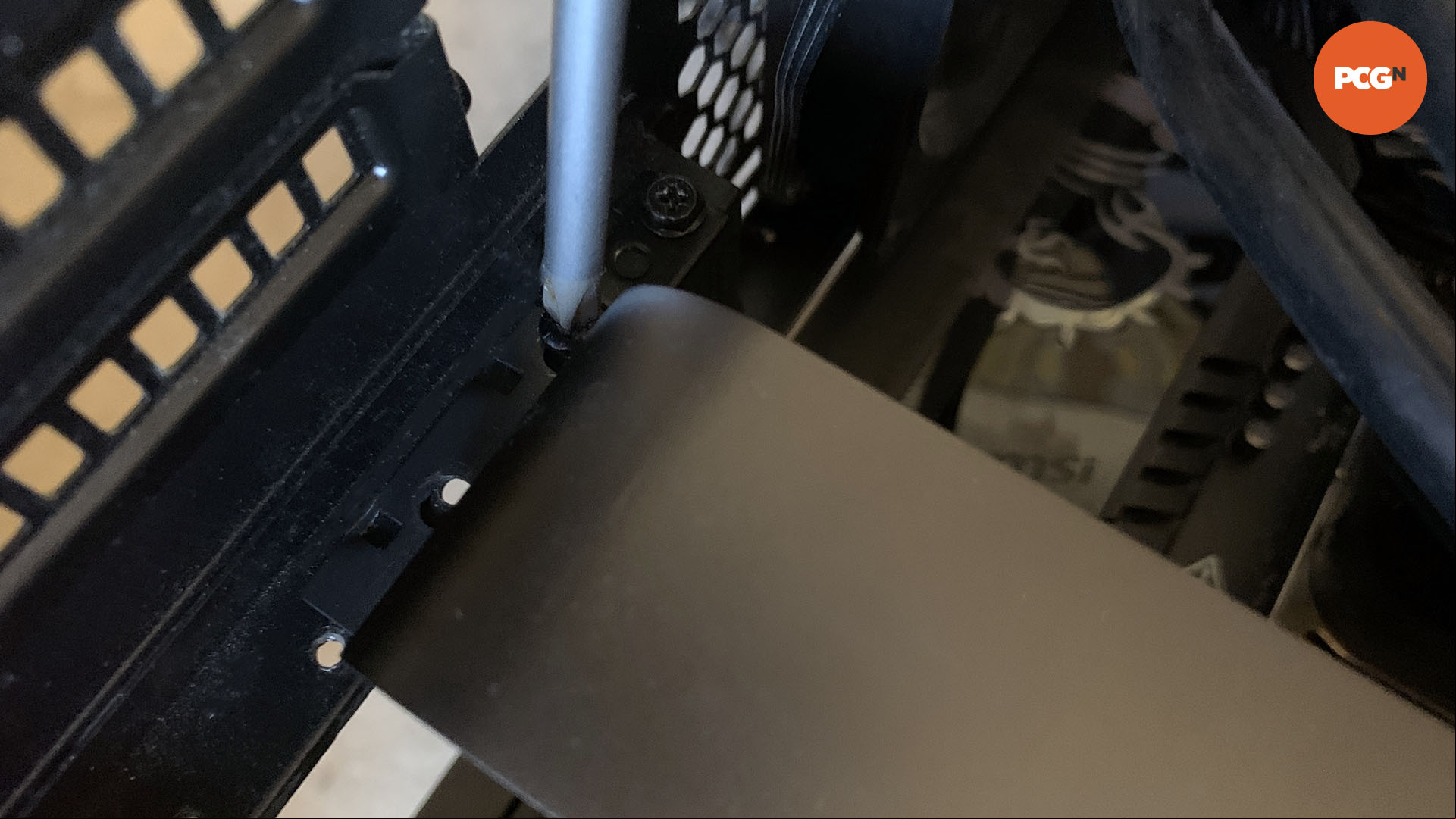 How to install a graphics card: Screw Nvidia GeForce RTX 5090 into case.