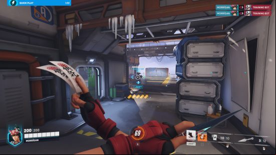 Overwatch 2 review: A woman holding ninja stars and tokens across her chest looks at a robot