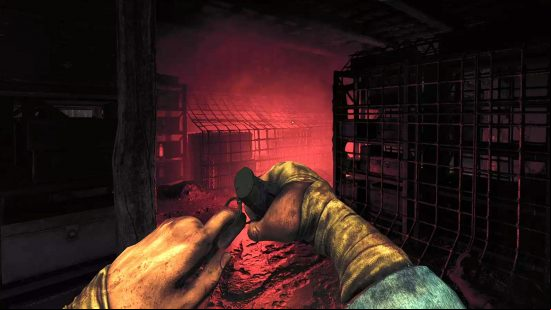 Amnesia The Bunker release date: A screenshot of the player about to unpin a grenade and throw into a gloomy store room lit up with an eerie red glow