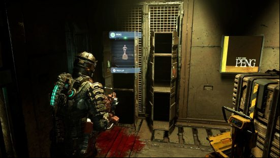 Dead Space peng: Isaac stands in the cargo bay facing a set of open lockers, one of which contains the elusive Peng treasure, as a stack of crates previously obstructing them sits to one side next to a Peng poster.