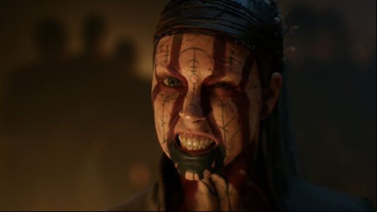 Senuas Saga Hellblade 2 release date: Senua's face is painted white, red, and blue, with runic inscriptions as she squints into the camera baring her teeth.