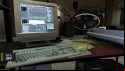 A screenshot from Half-Life 2, spotlighting a computer (left) and magnifying glass (right)