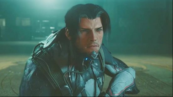 A man with black hair and a skintight outfit crouches and looks into the camera