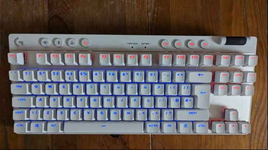 Logitech G Pro X TKL Lightspeed review: a white keyboard appears on a wooden worktop showing blue and orange RGB.