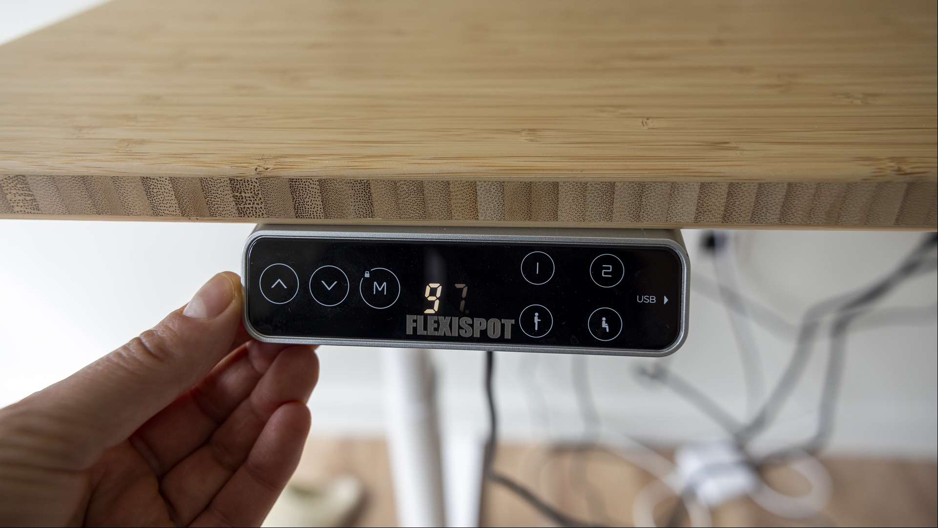 Flexispot E8 Standing Desk review image showing the USB 's screen near a human hand.