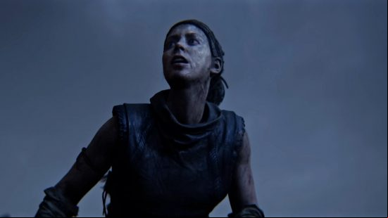 Senua stares up through fog and an overcast sky in Hellblade 2.