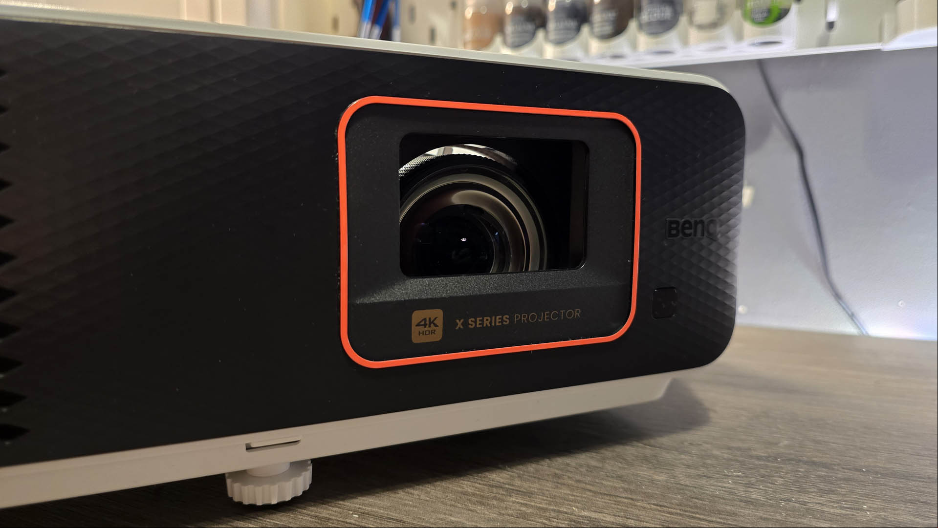 The lens of the The BenQ X500i gaming projector on a gray tabletop