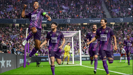 Best FM24 mods: a group of players celebrating in purple kits